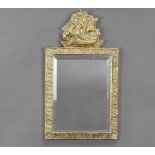 A rectangular bevelled plate wall mirror contained in an embossed brass frame surmounted by a