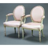 A pair of 19th/20th Century French white painted open arm salon chairs, the seats and backs