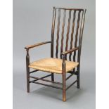 An Edwardian Voisey style beech framed open arm chair with woven rush seat 84cm h x 47cm w x 39cm (