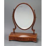 A 19th Century oval plate dressing table mirror contained in a mahogany swing frame, the crossbanded