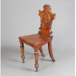 A Victorian mahogany hall chair with shaped back and solid seat, raised on cabriole supports 86cm