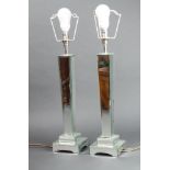 A pair of Art Deco style faceted tapered glass mirrored table lamps raised on square bases 42cm h
