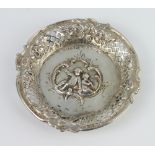 A 19th Century German repousse silver dish decorated with cherubs, scrolls and flowers, import marks