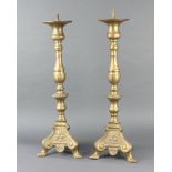 A pair of 17th Century style brass candlesticks, raised on panel supports 60cm h x 20cm w x 20cm d