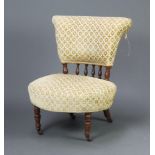 An Edwardian oak framed nursing chair with bobbin turned decoration upholstered in yellow