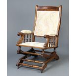 An American beech framed rocking armchair with upholstered seat and back, raised on turned