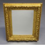 A 19th Century rectangular plate mirror contained in a decorative gilt cushion shaped frame 101cm