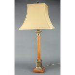 A turned and reeded mahogany and brass mounted table lamp in the form of a column on a stepped