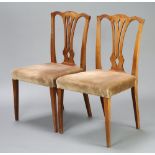 A pair of Georgian yew Hepplewhite style camel back dining chairs with over stuffed seats, raised on
