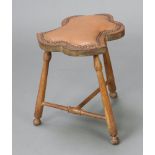 An Edwardian Art Nouveau shaped beech framed stool raised on turned supports with T framed stretcher