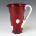 A 1960's red glass jug with white spots and handle 24cm