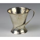 A Edwardian Arts and Crafts silver hammered pattern tapered mug with fancy handle London 1906 8cm,
