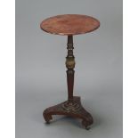A circular Regency mahogany wine table raised on a turned column with gilt embellishment and triform