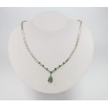 A white metal (stamped 750) emerald and diamond necklace comprising 1 pear cut emerald and 7
