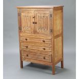 A 1930's Heals style limed oak tallboy enclosed by panelled doors above 3 drawers, having
