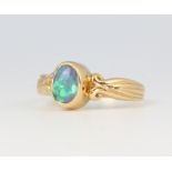 An 18ct yellow gold oval black opal ring, size L 1/2, 3.6 grams