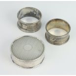 An Edwardian circular silver engine turned trinket box London 1907, 2 napkin rings 108 grams