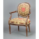 A 1930's carved mahogany open arm salon chair, the seat and back upholstered in floral material,