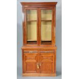 An Edwardian Art Nouveau mahogany cabinet on cabinet, the upper section with moulded cornice, the