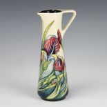 A contemporary Moorcroft cream ground jug decorated with Iris and having blue interior,