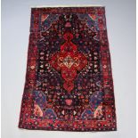 A red and blue ground Persian Kurdish rug with central medallion 259cm x 153cm Signs of moth and