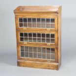 An Edwardian oak Globe Wernicke style 3 tier bookcase with 3/4 gallery enclosed by lead glazed