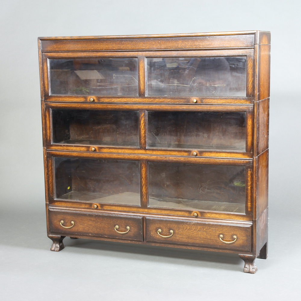 An oak Globe Wernicke style 3 tier bookcase enclosed by glass sliding panelled doors, the base
