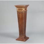 An Edwardian square carved walnut tapered pedestal with blind fretwork decoration, raised on a