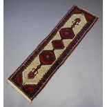 A white and red ground Sarab runner with 3 stylised diamonds to the centre within a multi row border
