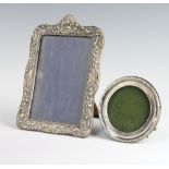 A circular silver photograph frame (rubbed marks) 9cm diam. together with a repousse ditto (a/f)