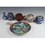 A 20th Century Chinese famille rose plate decorated with panels of flowers 30cm, a tanware teapot, 1