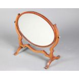 A 19th Century oval bevelled plate dressing table mirror contained in a mahogany swing frame 59cm