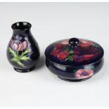 A contemporary Moorcroft blue ground pot and cover decorated with anemones 12cm together with a