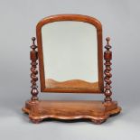 A Victorian arched plate dressing table mirror contained in a mahogany frame with spiral turned