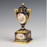 An Austrian blue and gilt 2 handled vase decorated with spring flowers, raised on a square plinth