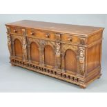 An Ipswich style carved oak sideboard fitted 3 drawers above triple cupboard enclosed by panelled