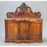 A Victorian mahogany chiffonier with carved raised back, the base of serpentine outline fitted 2