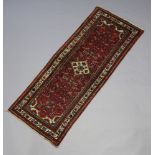 A Persian red, white and green patterned Malayer runner with central diamond medallion 202cm x