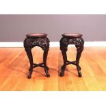 A pair of ebonised and marble topped urns stands, 60cms high.