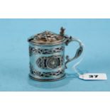 A GEORGE V CIRCULAR IRISH SILVER CELTIC INFLUENCE MUSTARD POT AND COVER, blue glass liner, decorated