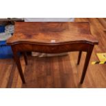 A GEORGE III MAHOGANY FOLD OVER TOP TEA TABLE, the serpentine top above a frieze drawer raised on