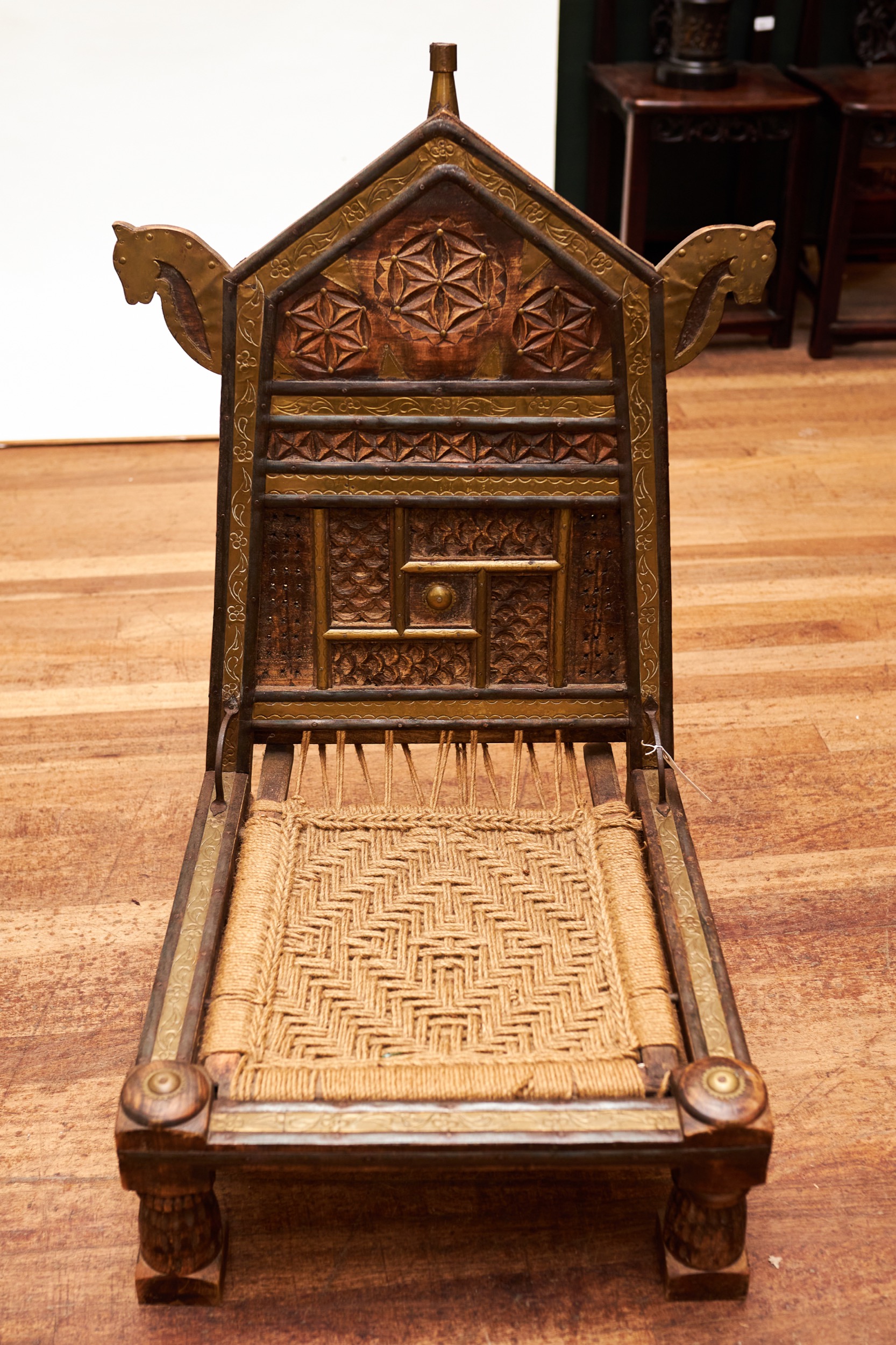 A 20TH CENTURY AFRICAN BRASS MOUNTED TENT CHAIR, with woven seat raised on short turned legs.