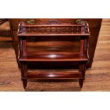 A SET OF EDWARDIAN MAHOGANY THREE TIER HANGING SHELVES with pierced ends, 26 ins wide and a DITTO