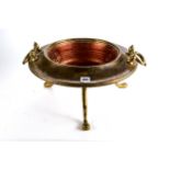 A 20TH CENTURY CIRCULAR COPPER AND BRASS FIRE BOWL, twin handles raised on three shaped legs and paw