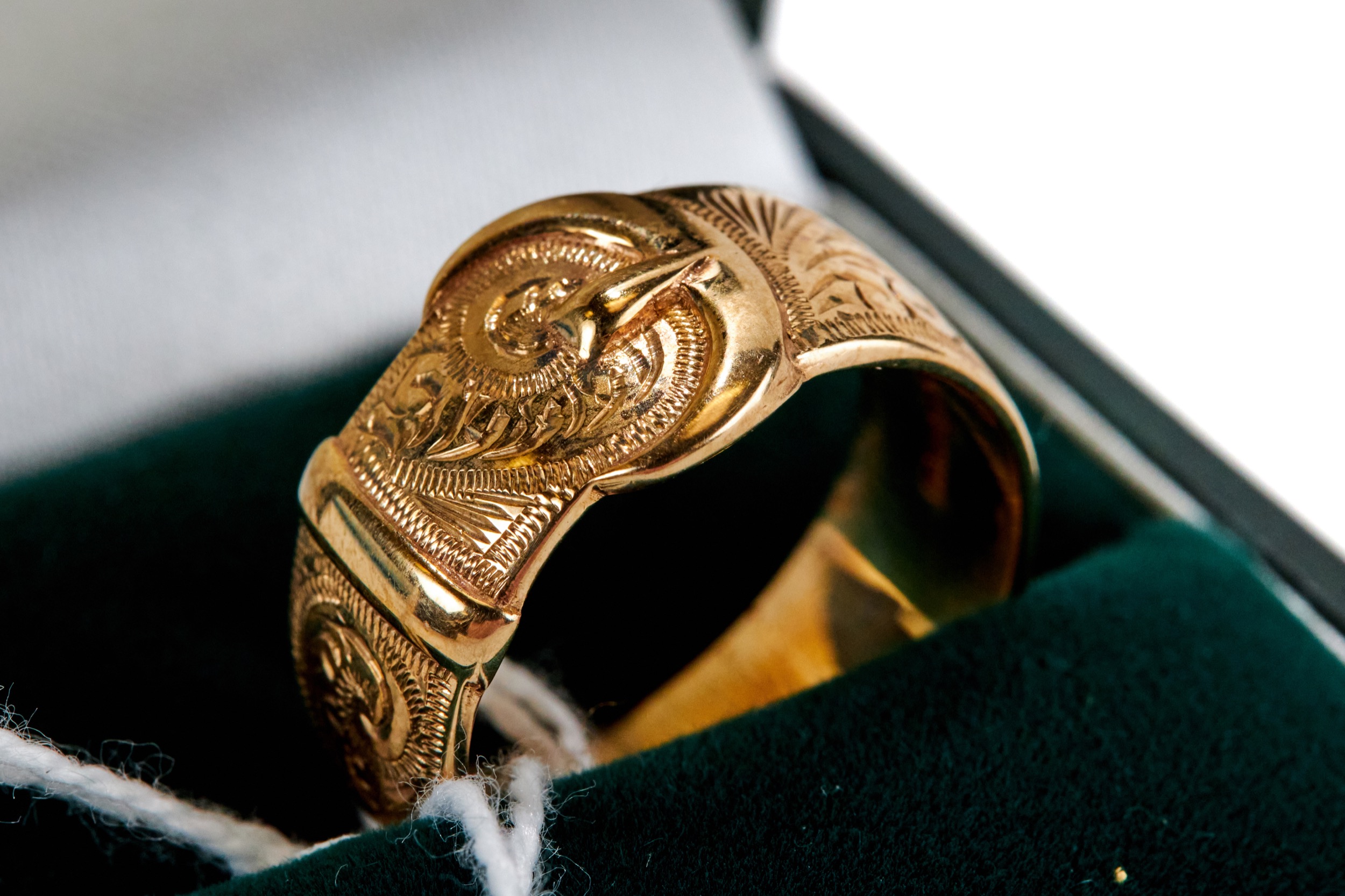 A 9CT YELLOW GOLD FOLIATE ENGRAVED BUCKLE RING, size R, approximately 7 grams.