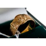 A 9CT YELLOW GOLD FOLIATE ENGRAVED BUCKLE RING, size R, approximately 7 grams.