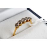 A YELLOW GOLD FIVE STONE COLLET-SET DIAMOND RING, unmarked, size O, approximately 2.3 grams.