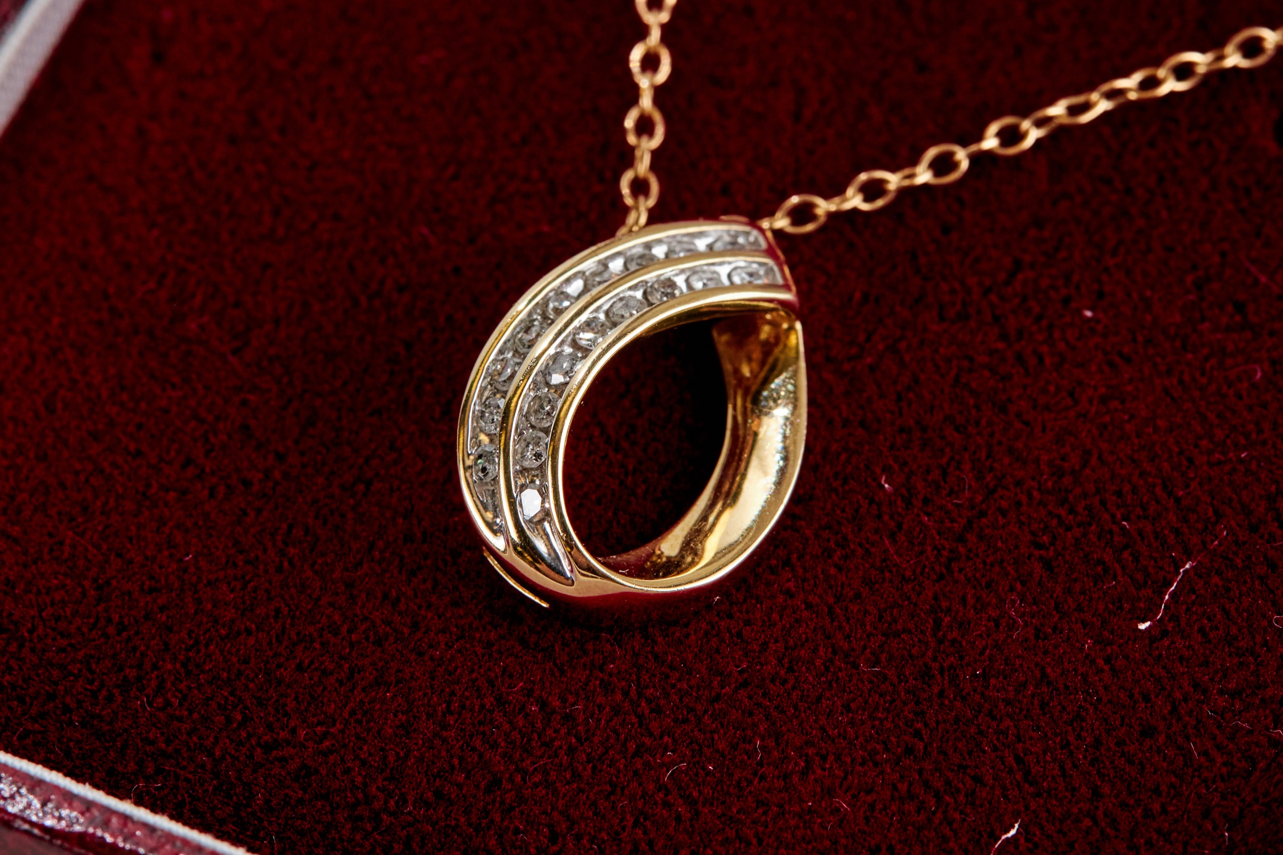 A 10K YELLOW GOLD PEAR SHAPED PENDANT, set with eighteen diamonds on a 9ct gold neckchain,