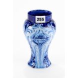 AN EARLY 20TH CENTURY MACINTYRE FLORIAN WARE BLUE GROUND POTTERY VASE, baluster shape decorated with