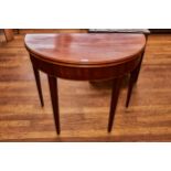 A GEORGE III MAHOGANY HALF ROUND FOLD OVER TOP TEA TABLE, boxwood branded frieze, raised on square
